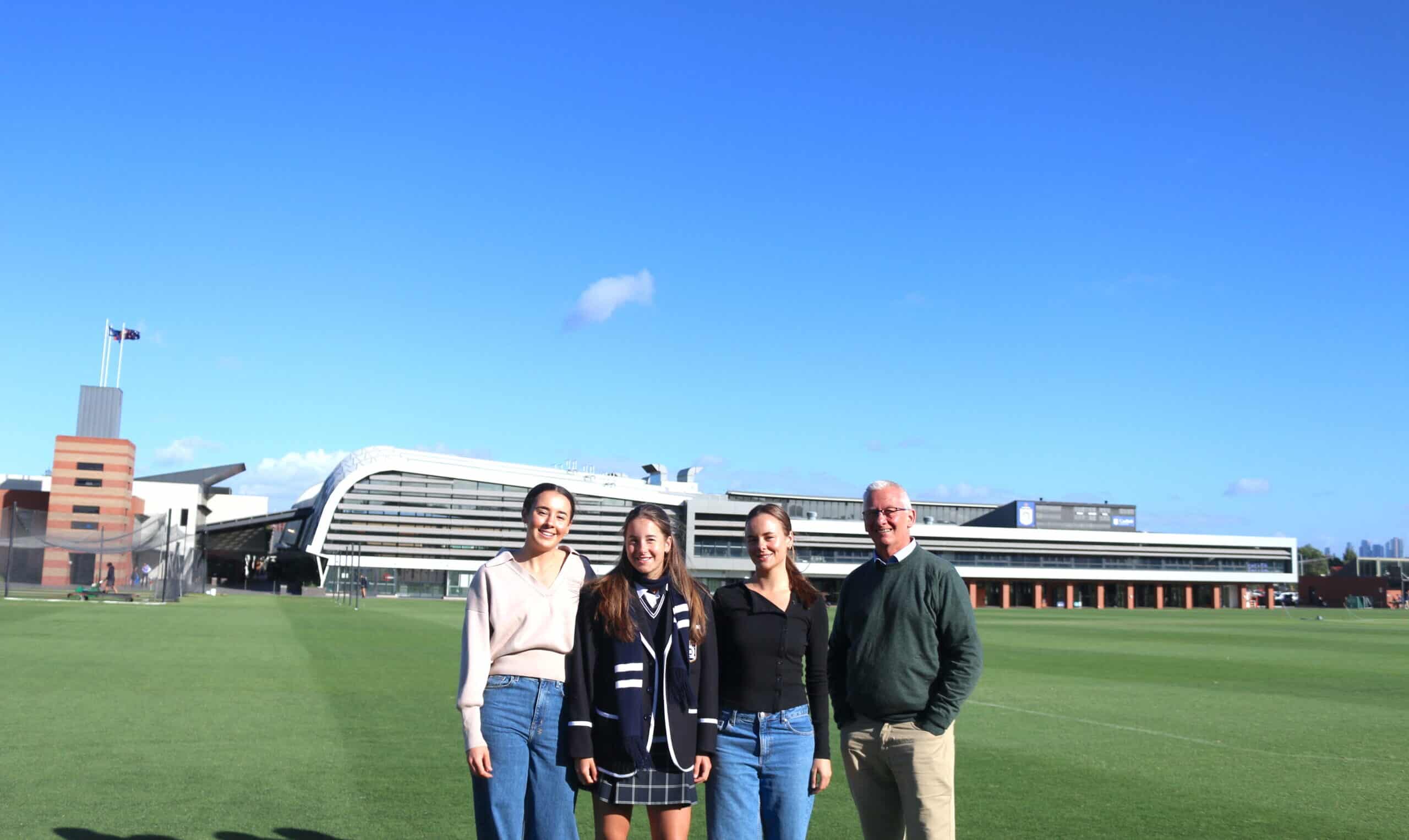 From left: Greta, Maeve and Scarlett Sheldrick with Caulfield Grammar School’s head of boarding, Tim Gallop.