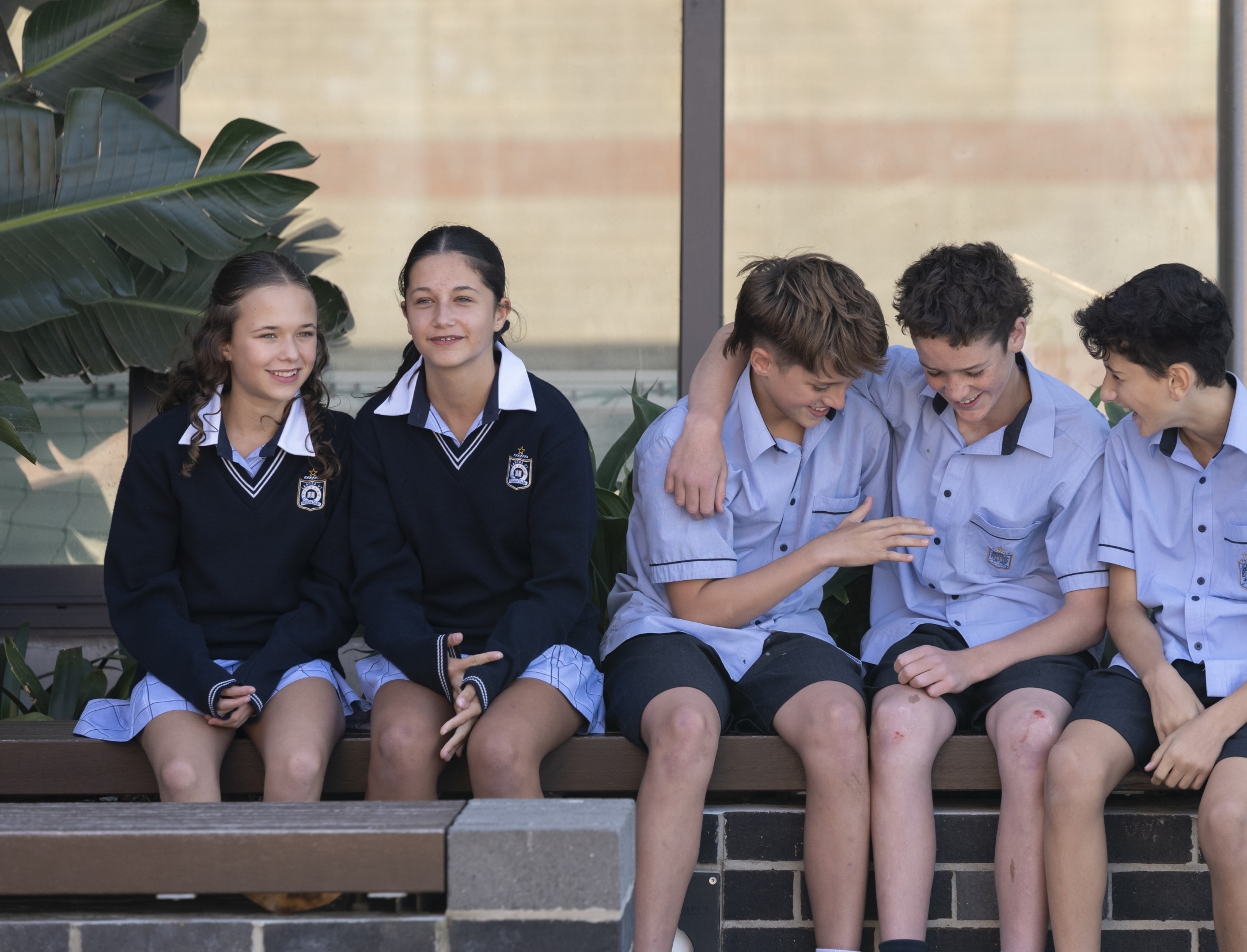 A group of middle school student sitting outside and talking