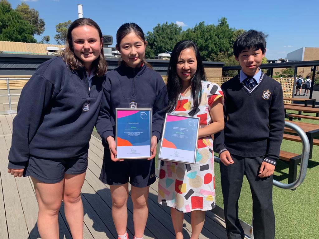 Students and their teacher receiving a Bloom award