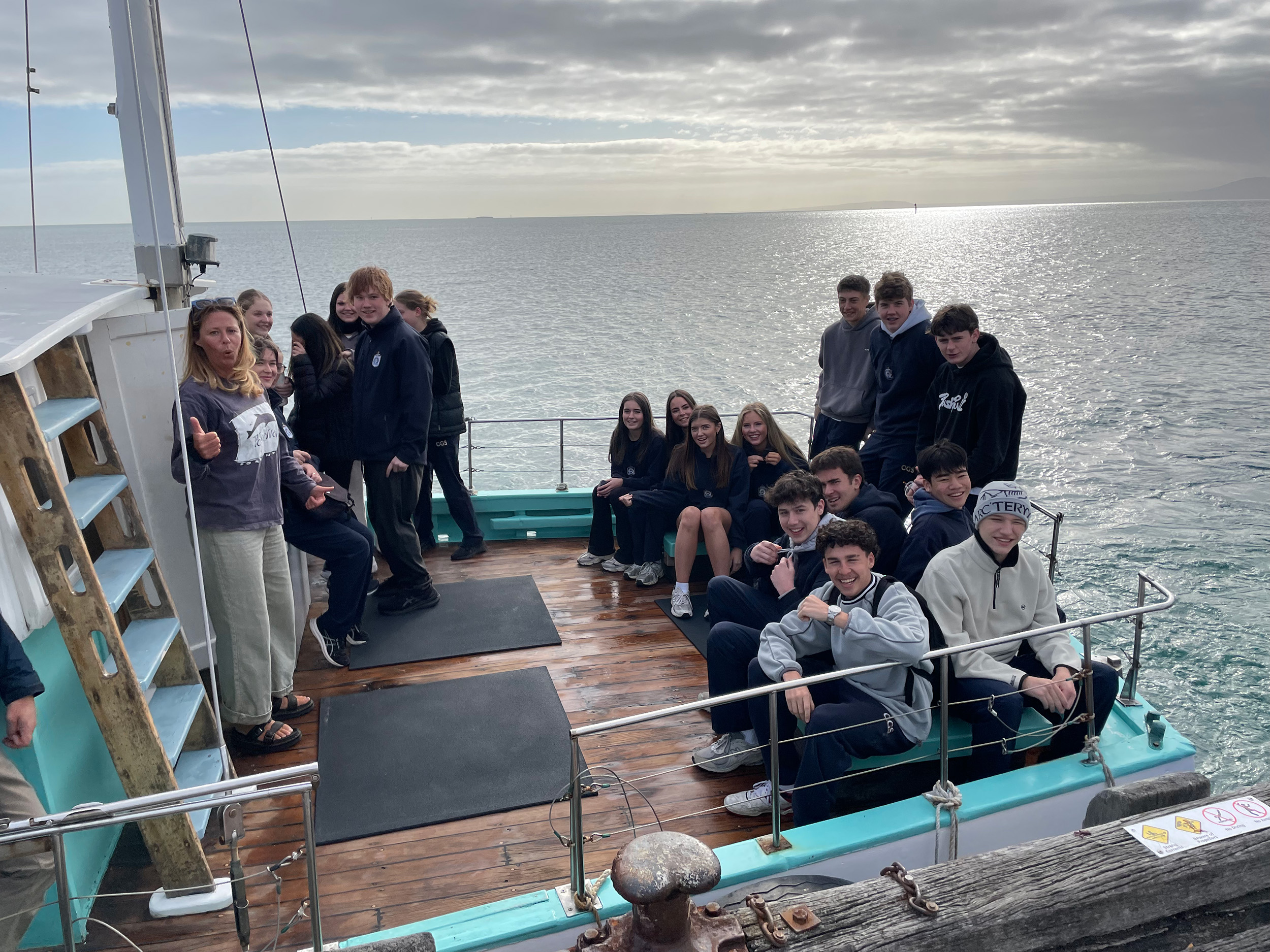 A group of students sitting on a boat during a Senior School Outdoor Education excursion.