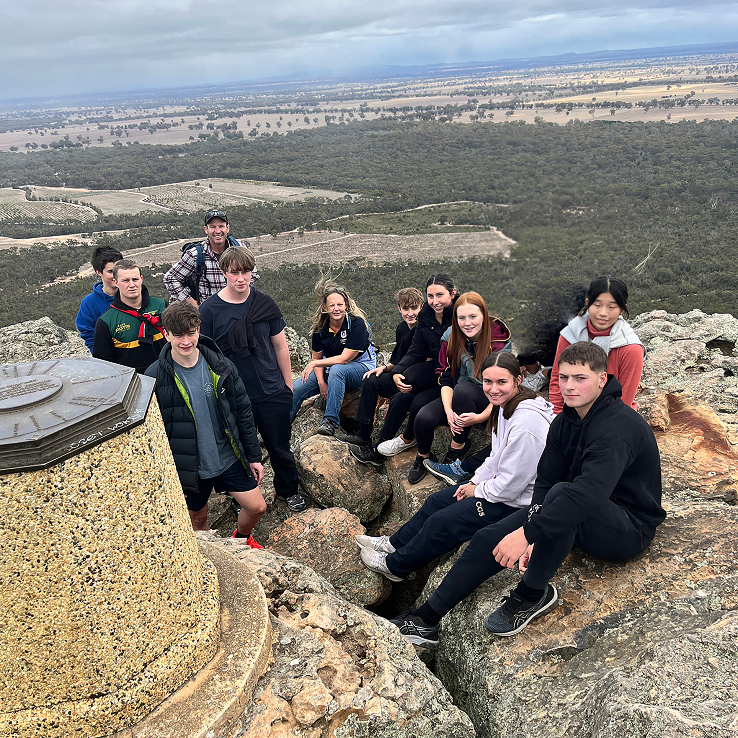 Group of students sitting on large rocks during an excursion