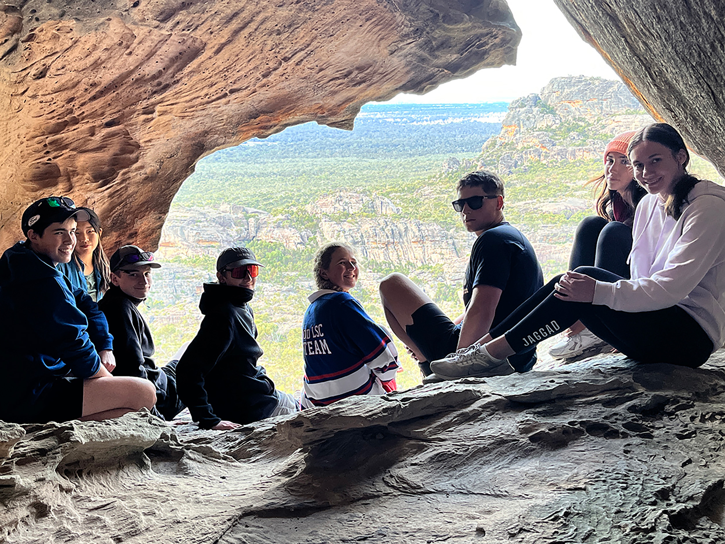 Group of students sitting on large rocks during an excursion