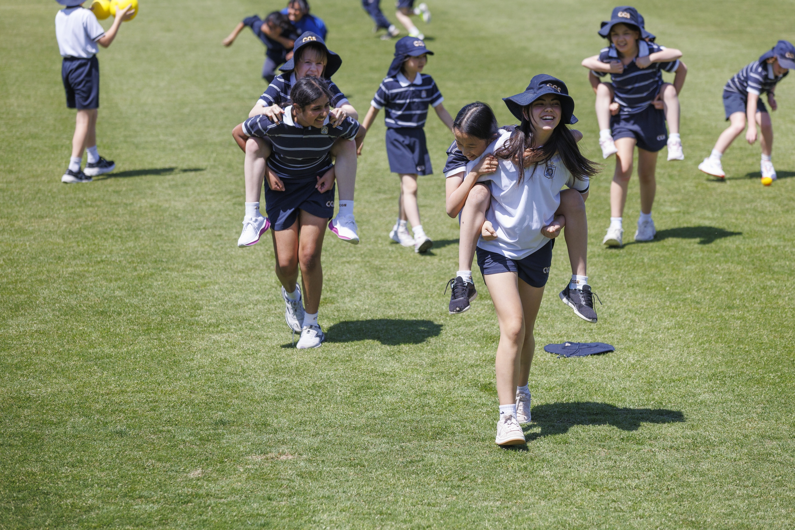 A group of young girls joyfully playing sports on a green field
