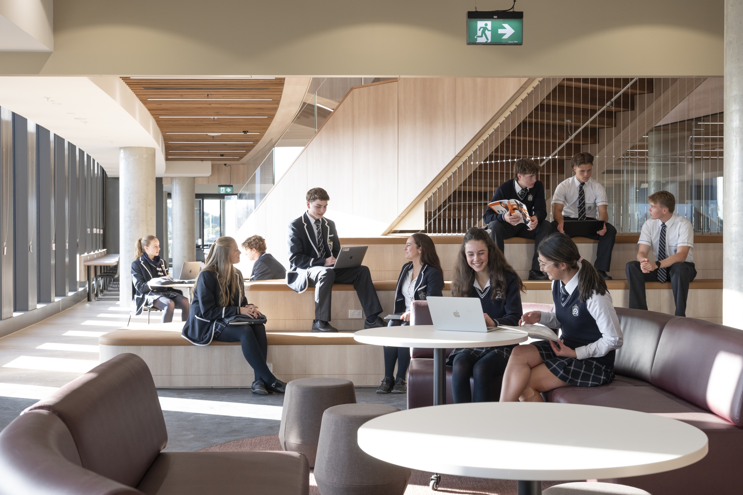 A group of Caulfield Grammar School seniors sits on couches in the lobby, socialising and relaxing between classes.