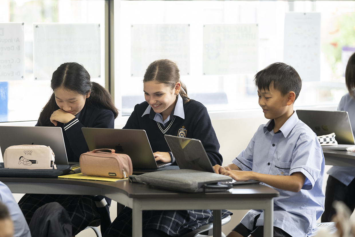 Students working on their laptop in a classroom setting